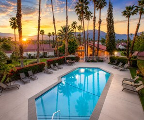 A swimming pool with lounge chairs and palm trees, surrounded by a landscaped garden and a building with a red roof. - 25% Off Sept 10-13 Perfect 4 Families Pool, Tennis (Palm Springs)