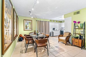 A dining area with a round table, chairs, and a kitchen in the background. - 25% Off Oct 22-25 Perfect 4 Families Pool, Tennis! (Palm Springs)