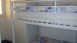 Una cama litera con estructura metálica blanca y un colchón estampado con motivos florales.