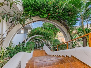 A staircase with a white railing, surrounded by greenery and plants. - Modern Studio in Costa Adeje with Spacious Terrace (Costa Adeje)
