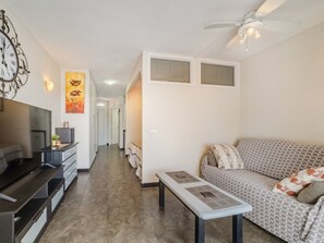 A modern living room with a sofa, a coffee table, and a TV. - Modern Studio in Costa Adeje with Spacious Terrace (Costa Adeje)