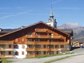 Ein Holzgebäude mit mehreren Balkonen und einem Uhrturm.
