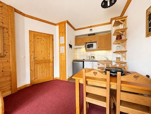 A compact kitchen with wooden cabinets, a microwave, and a coffee maker. - Cozy apartment, pets welcome - 4 guests (Notre-Dame-de-Bellecombe)