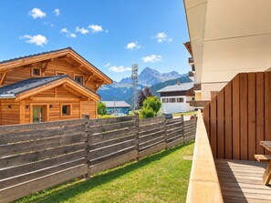 Una cabaña de madera con terraza y vista a la montaña.