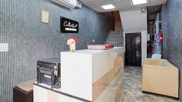 A reception desk with a sign that reads 'Collection,' a vase with flowers, and a water dispenser.