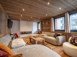 Ein gemütliches Wohnzimmer mit einer Couch, einem Couchtisch und einem Kamin.