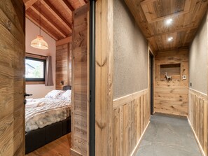 Ein Holzinterieur mit einem Bett, einer Pendelleuchte und Wanddekoration.