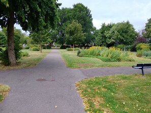 Ein Parkweg mit einer Bank am rechten Rand.