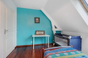 A room with a sloped ceiling, a bunk bed, a small table, and a framed picture on the wall. - Modern villa 200 m from the beach with Wi-Fi (Saint-Vaast-la-Hougue)