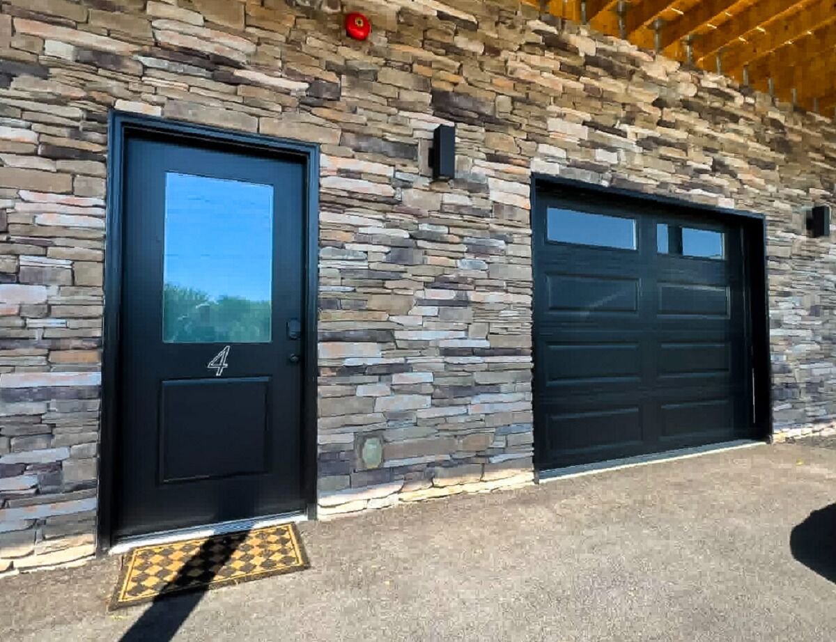 A building with two garage doors and a stone facade.