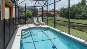 A swimming pool with a view of a residential area, surrounded by a fence, and a clear sky above. - 5BR Veranda Palms Home Near Disney for 14 (Kissimmee)