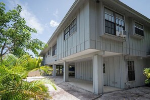 Ein zweistöckiges Gebäude mit einer Veranda und einer Garage.