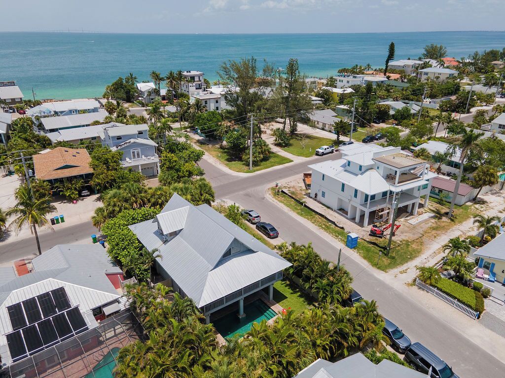 Un quartier résidentiel avec des maisons, une route et une vue sur l’océan.