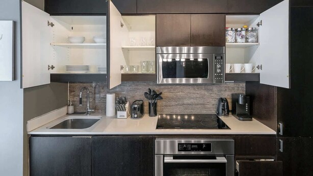 Eine moderne Küche mit integriertem Mikrowellenherd, Backofen und Kaffeemaschine.