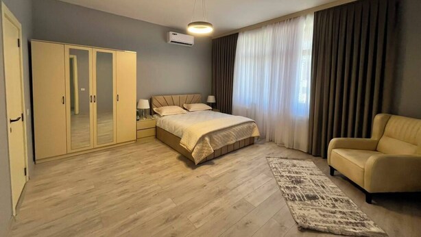 Un dormitorio con cama, armario y zona de estar.