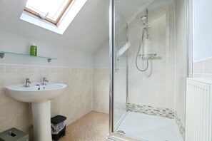 Een douche, handdoeken, zeep, toiletpapier