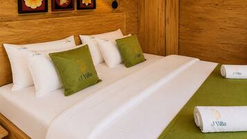 Una cama bien hecha con sábanas blancas, almohadas y una manta de color verde, además de una toalla con un logotipo.