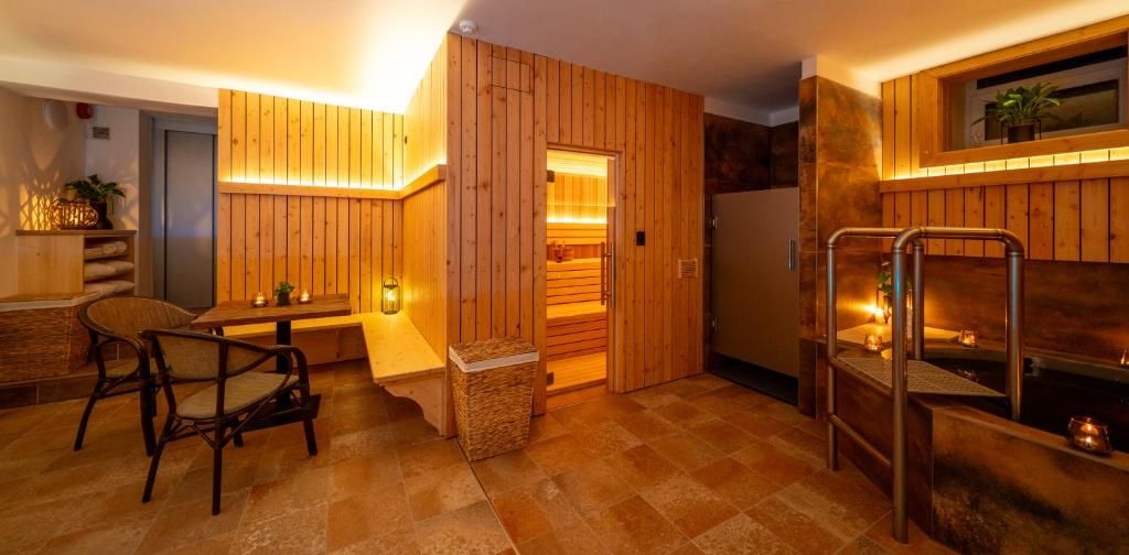 Een houten interieur met een sauna, een zithoek en een kleine tafel met kaarsen.