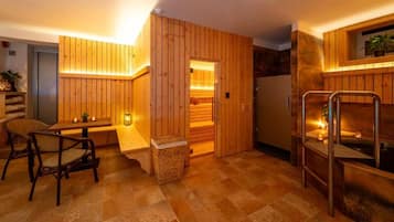 Een houten interieur met een sauna, een zithoek en een kleine tafel met kaarsen.