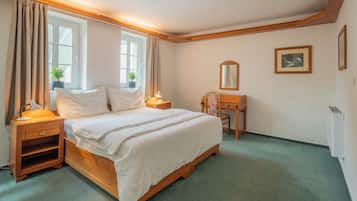 Une chambre à coucher bien rangée, avec un lit, des tables de chevet, un bureau et une chaise.