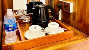 Una bandeja de madera con una tetera, tazas y una botella de agua.