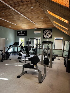 A gym with various exercise equipment, including treadmills, weight machines, and free weights.