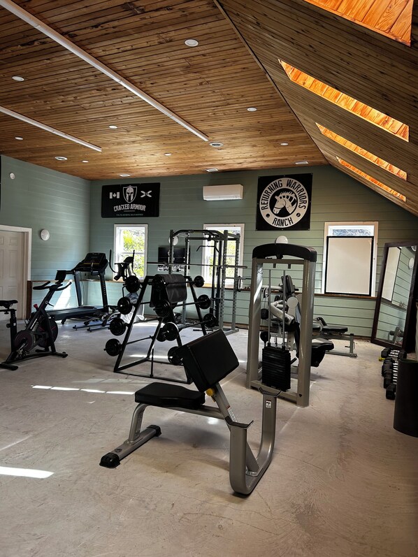 A gym with various exercise equipment, including treadmills, weight machines, and free weights.