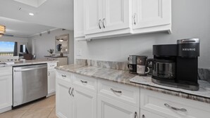 A modern kitchen with white cabinetry, a coffee maker, and a countertop. - Carlos Pointe #213 Paradise Pointe (Fort Myers Beach)