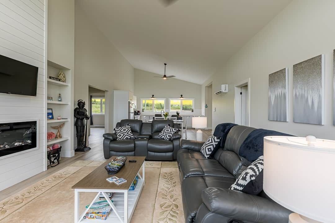 A spacious living room with a fireplace, a sofa set, a coffee table, and a television.