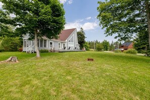 A house with a covered porch and a well-maintained lawn. - Lupin Lane Beach Retreat (Stratford)