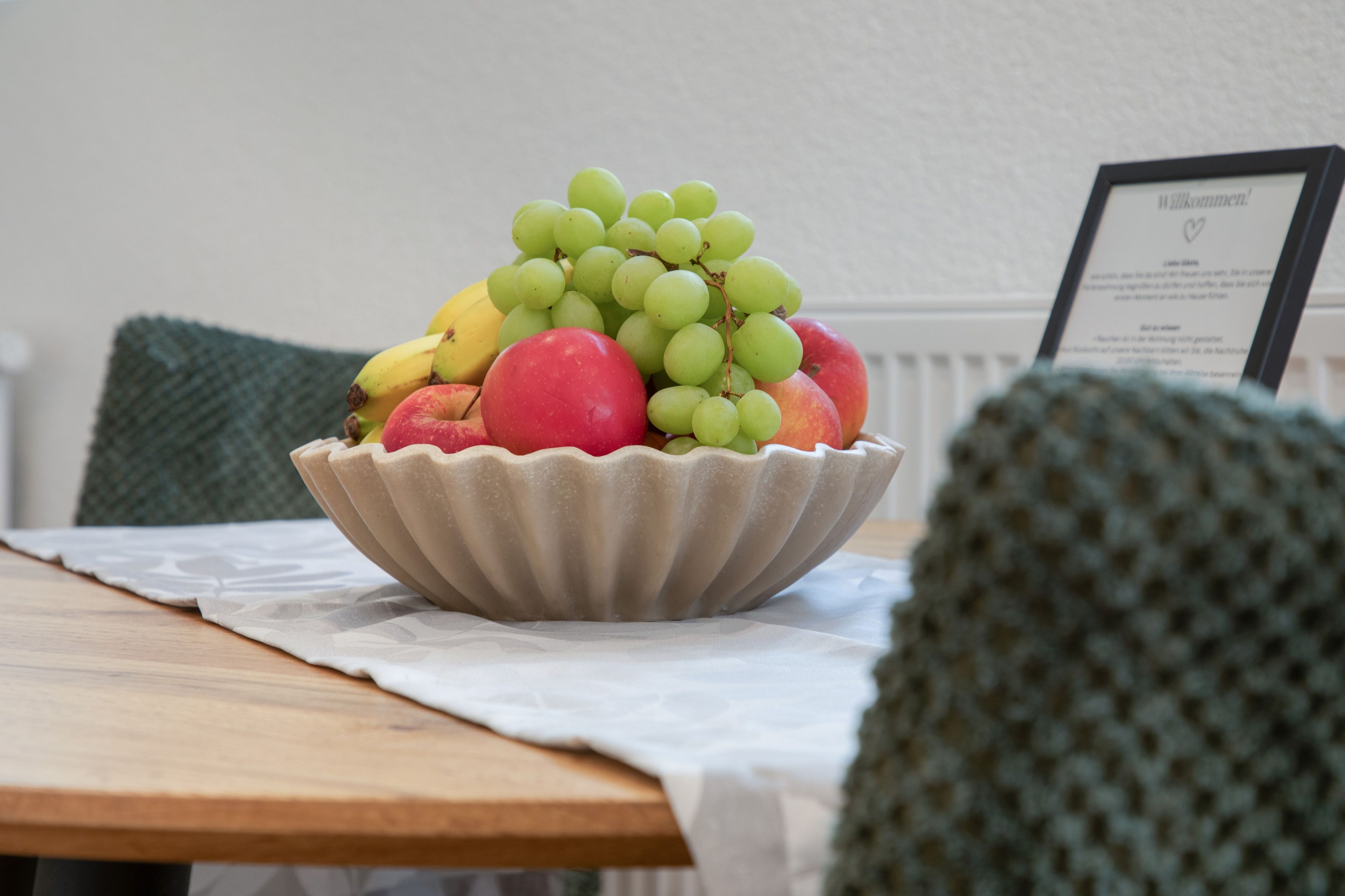 Un tazón de fruta sobre una mesa con mantel blanco.