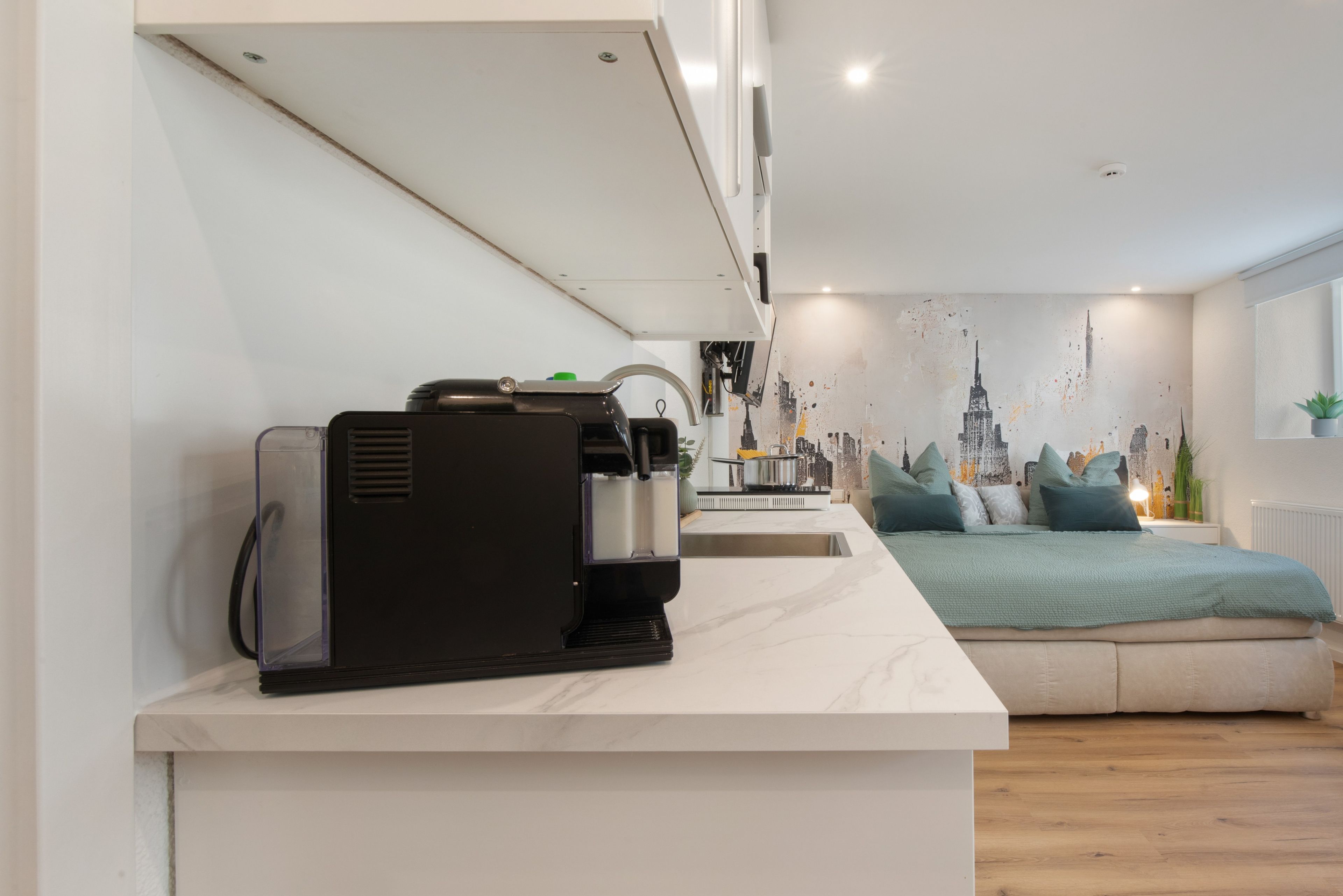 Uma cozinha moderna com máquina de café expresso embutida, pia e fogão.