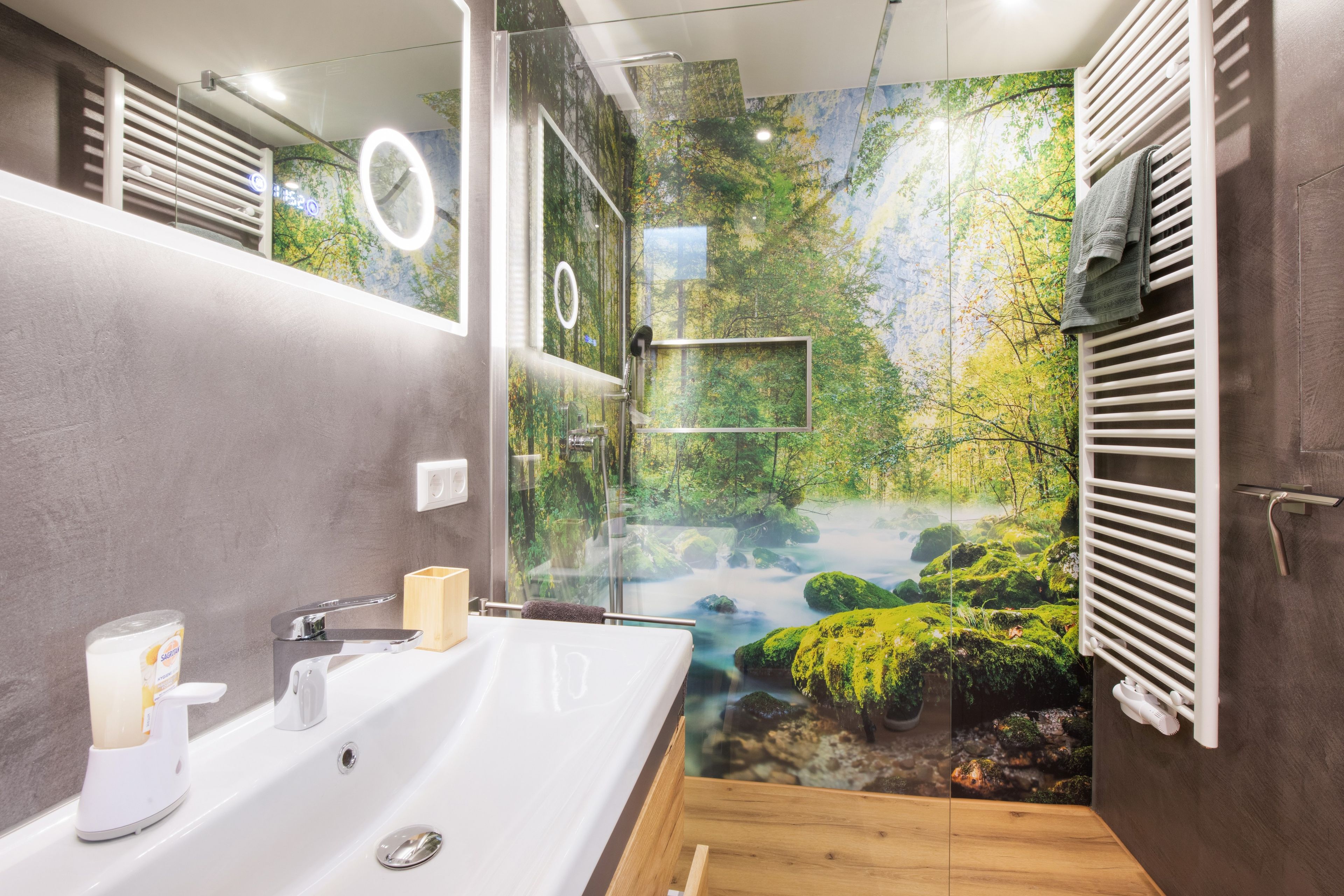 Ein modernes Badezimmer mit großem Spiegel, Waschbecken und Duschbereich.