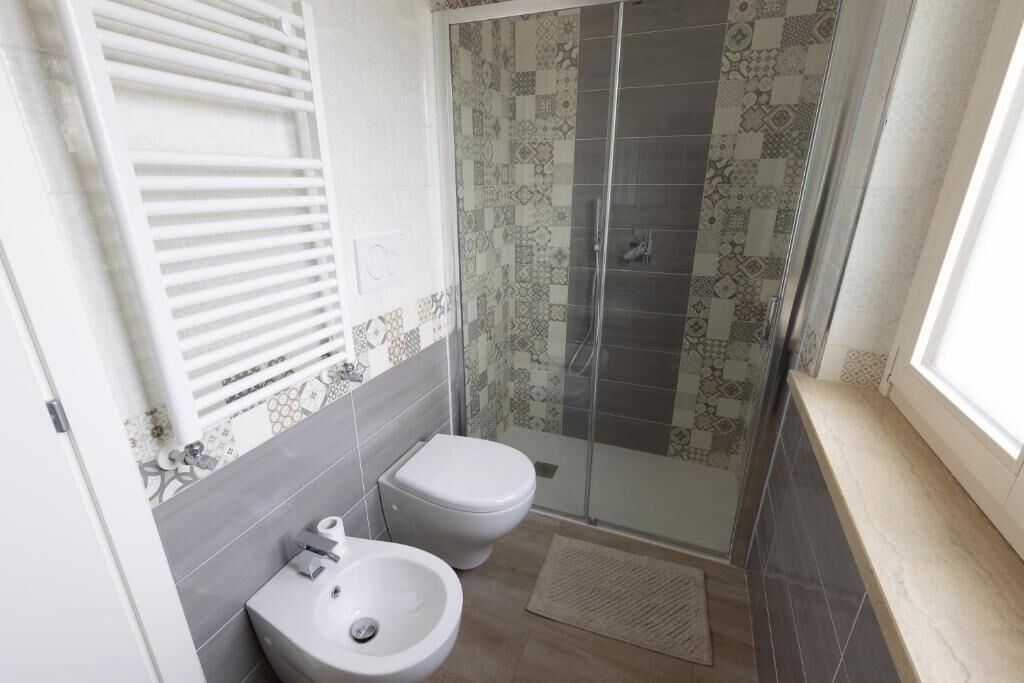 Une salle de bain comprenant des toilettes, un bidet et un espace douche.