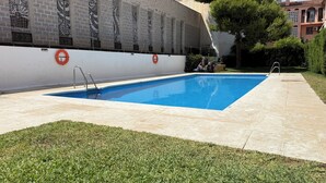 A swimming pool with a tiled deck, surrounded by a low wall with decorative patterns. - Salamanca Urban (Málaga)