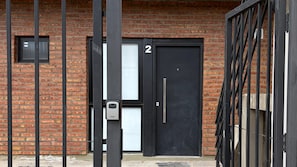 A black door with the number 2, a window, and a metal gate.