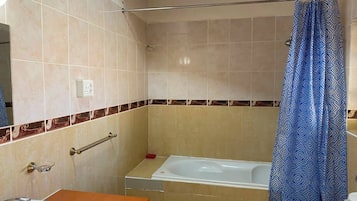 A bathroom with a bathtub, a toilet, and a sink.