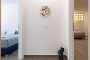 A bedroom with a bed, a wall-mounted light switch, and a cat-shaped decoration. - Bright home 200m from the Beach (Porto Rafti)
