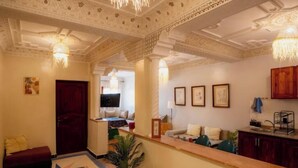 A hotel lobby with a reception desk, seating area, and a decorative ceiling. - Bright Apartment & Rooftop Terrace (Essaouira)