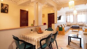 A dining area with a checkered tablecloth, chairs, and a decorative vase. - Bright Apartment & Rooftop Terrace (Essaouira)