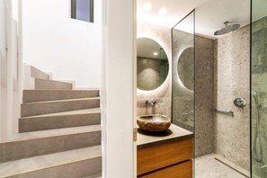 A modern bathroom with a stone sink, a glass-enclosed shower, and a staircase leading to another level. - Kamelia Luxury Villa 2 (Hersonissos)
