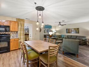 Une cuisine moderne avec un coin repas, un canapé et un ventilateur de plafond.