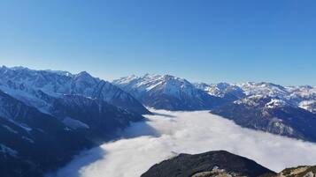 A mountain landscape with snow-capped peaks and a valley below.
