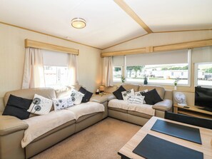 A cozy living room with a sofa, a coffee table, and a TV. - Rowan View 251 (Dunbar)