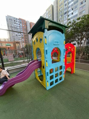 A playground with a slide and climbing structures.