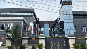 En moderne bygning med en glasfacade, et tydeligt skilt med 'VINGSTONE' og en portindgang med dekorative detaljer.