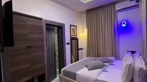 Et moderne hotelværelse med seng, garderobeskab og en lampe i loftet.