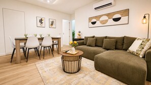 A modern living room with a sofa, a dining table with chairs, and a coffee table. - ATLANTIC BEACH APARTMENT (Quarteira)