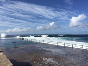 Ein Schwimmbecken mit Blick auf den Ozean und Wellen.