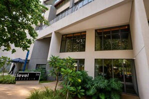 A modern building with multiple floors, large windows, and a sign indicating it is level 54. - Luxury apartment on the 25th floor with parking space and close to the Brooklyn Metro station. (São Paulo)